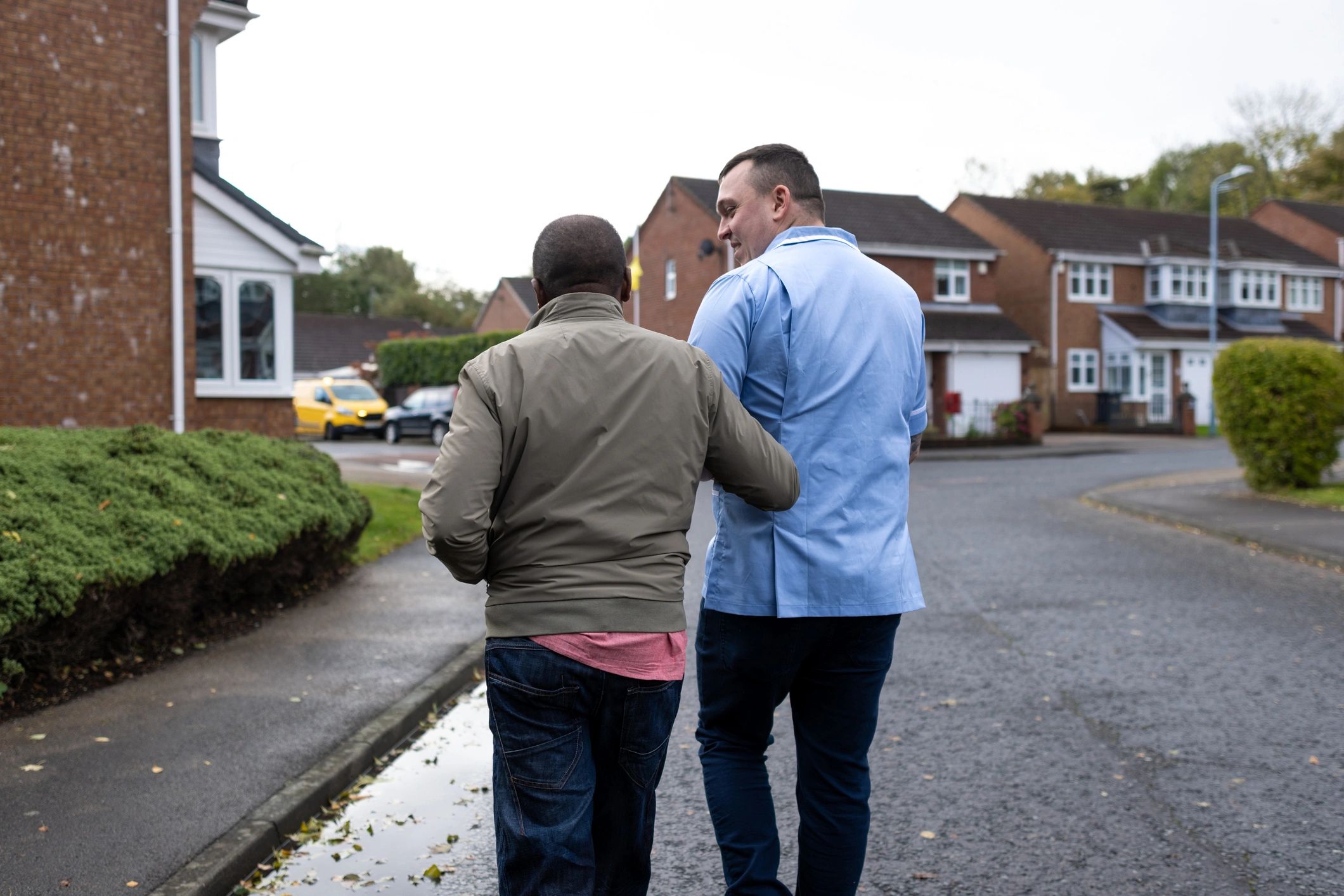 Support professional walking alongside a client outdoors